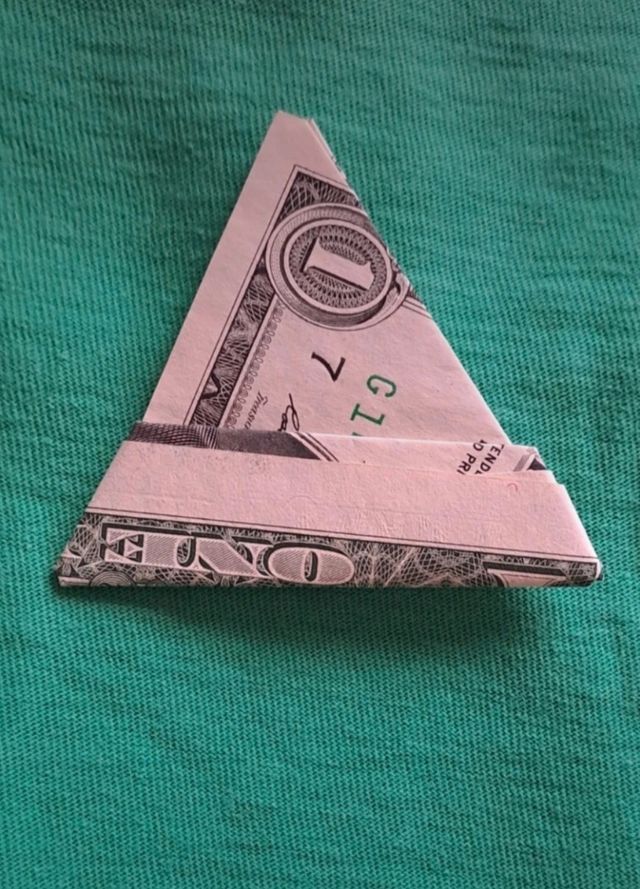 Dólar plegado en forma de triángulo. Amuleto para