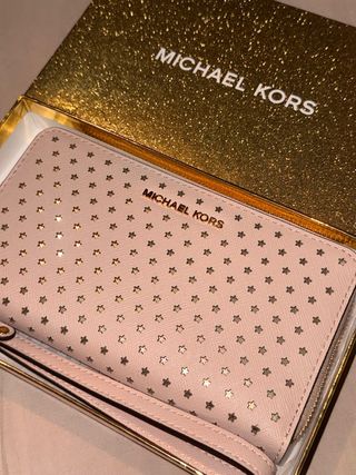 Monedero Michael Kors rosa con estrellas doradas.