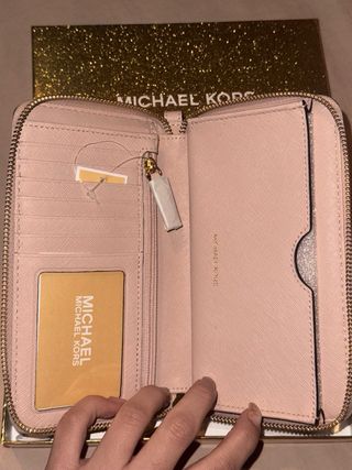 Monedero Michael Kors rosa con estrellas doradas.