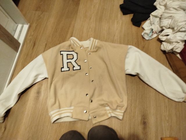 Chaqueta beige y blanca con letra R