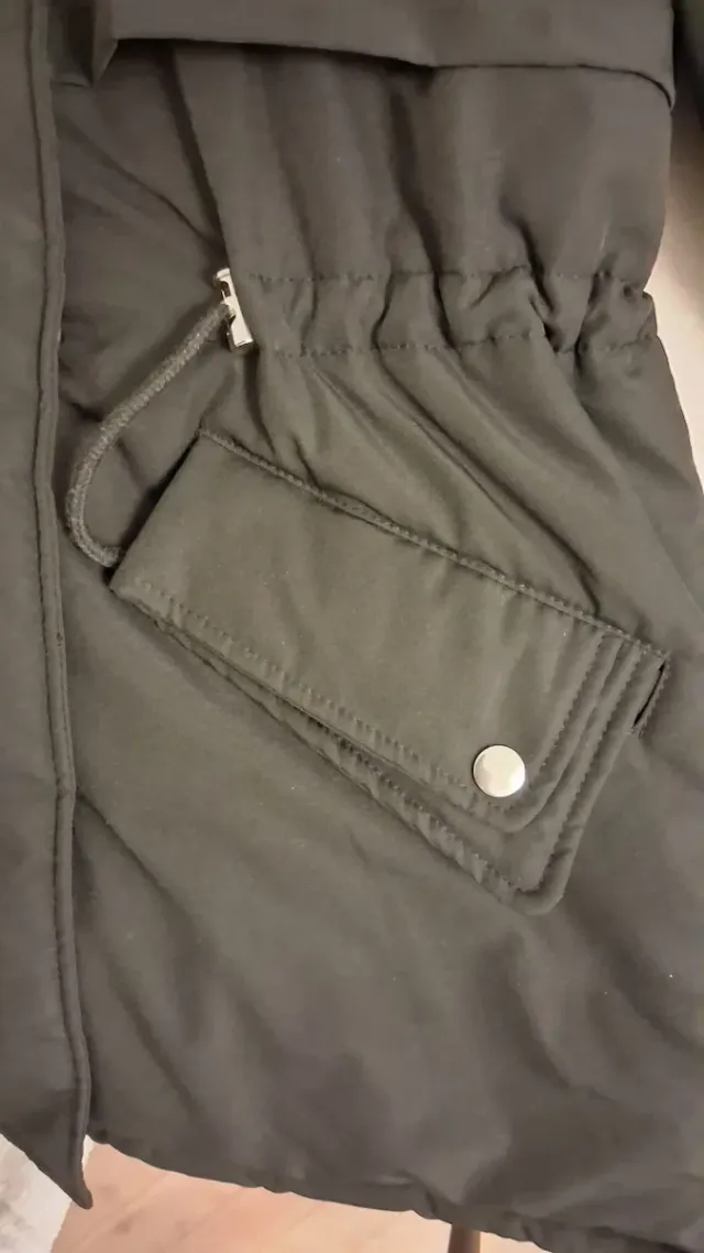 Abrigo negro con capucha de pelo.