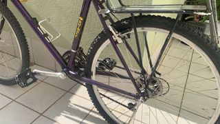 Bicicleta de ciudad y montaña morada full equipada