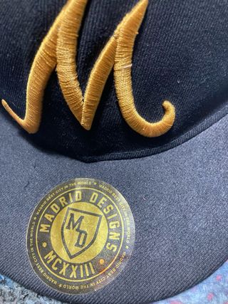 Gorra Madrid Designs Negra con M Dorada
