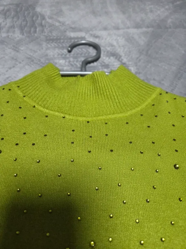 Jersey de punto verde con pedrería.