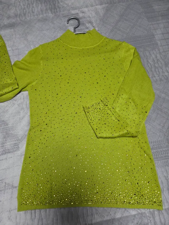 Jersey de punto verde con pedrería.