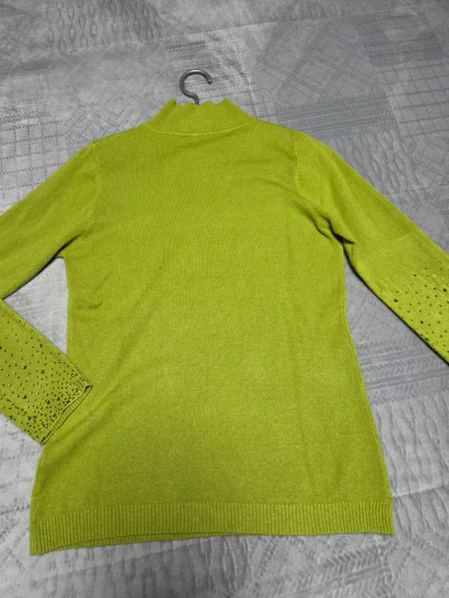 Jersey de punto verde con pedrería.