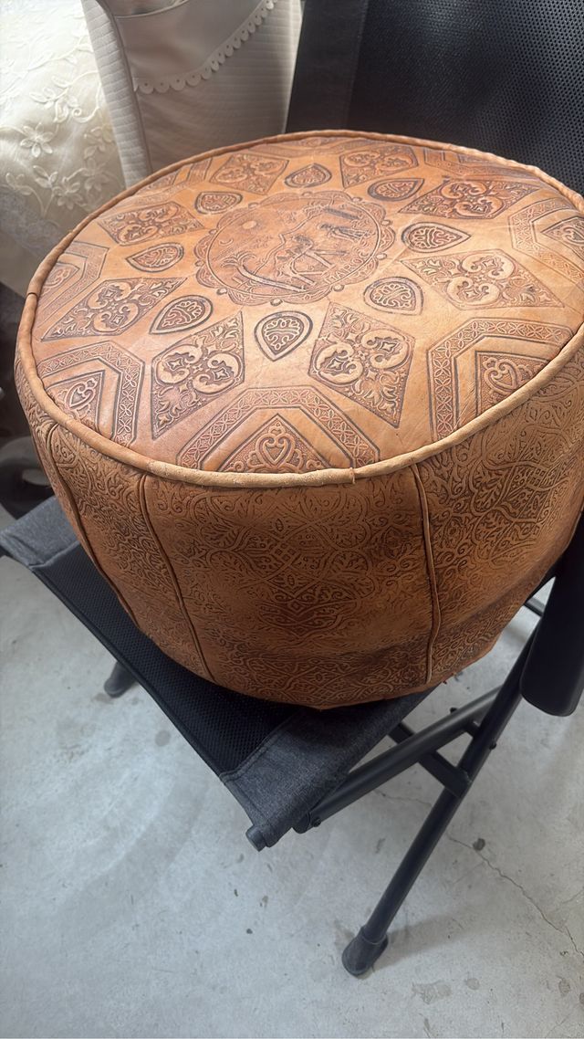 Puf de piel marrón con diseño labrado