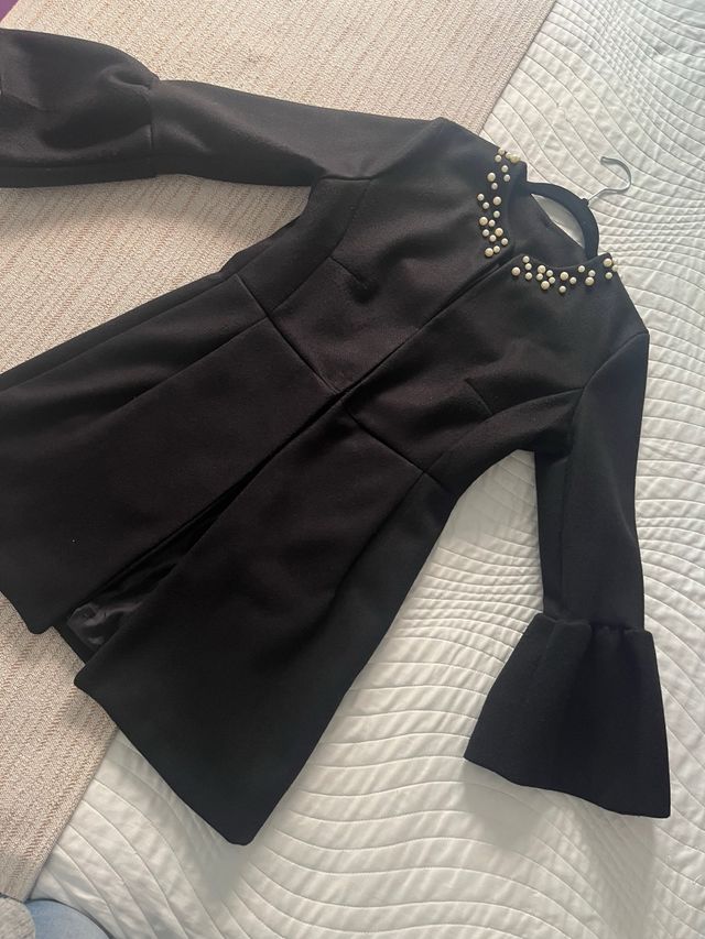 Abrigo negro mujer perlas.