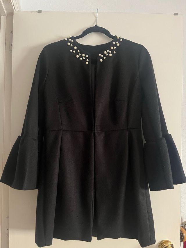 Abrigo negro mujer perlas.