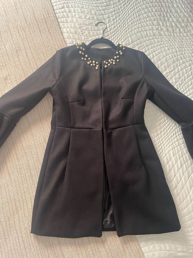 Abrigo negro mujer perlas.