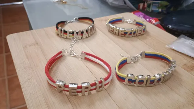Pulseras con dijes de la suerte y bandera,