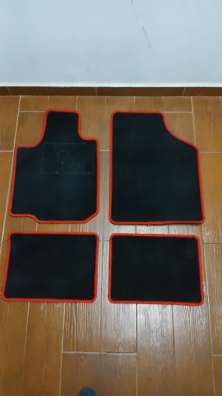 Alfombrillas coche negras con ribete rojo.