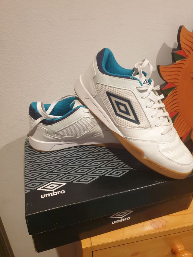 Zapatillas fútbol sala Umbro blancas y turquesa.