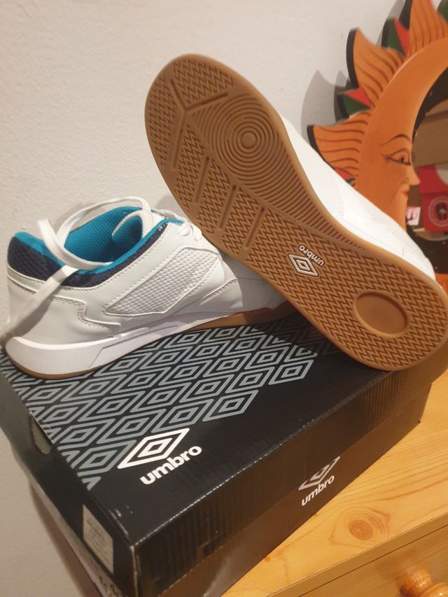 Zapatillas fútbol sala Umbro blancas y turquesa.