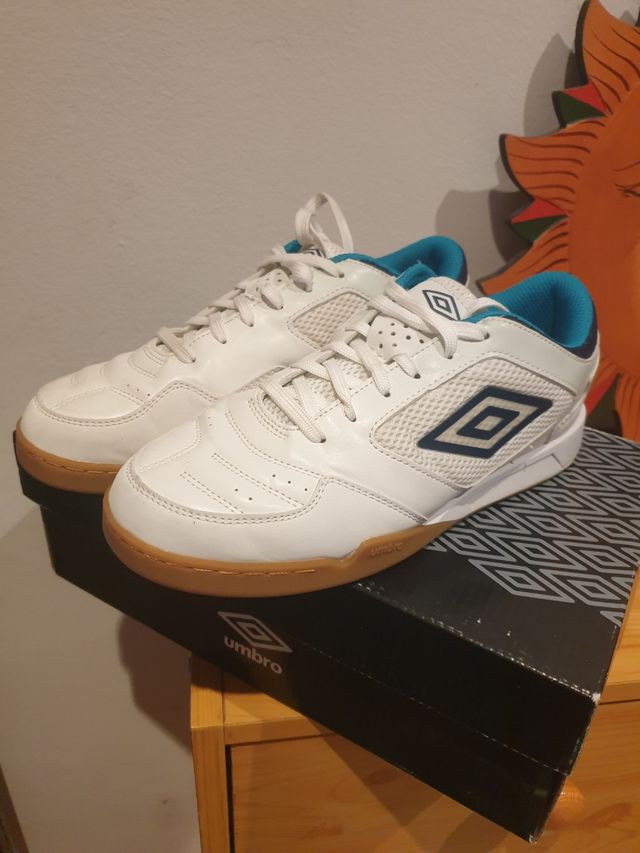 Zapatillas fútbol sala Umbro blancas y turquesa.