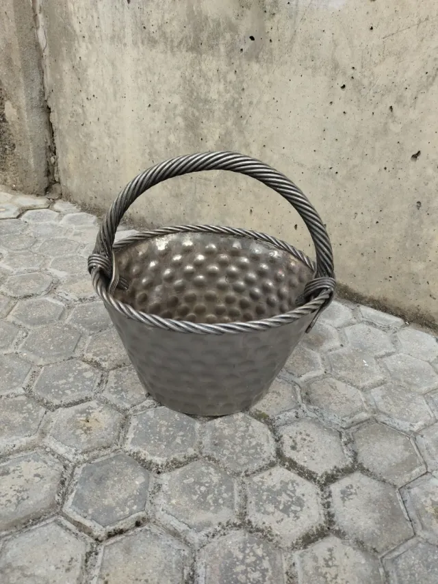 Canasto de metal plateado con asa