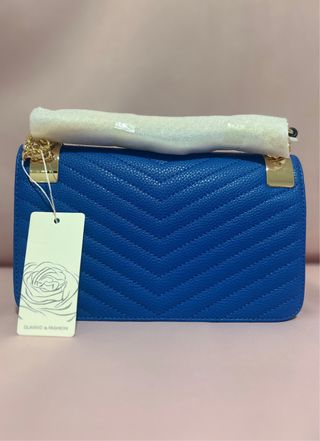 Cartera azul acolchada con detalles dorados