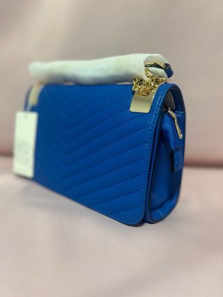 Cartera azul acolchada con detalles dorados
