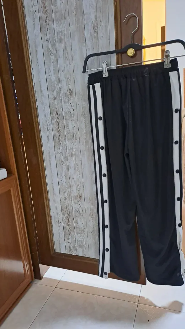 Pantalón deportivo negro con botones laterales