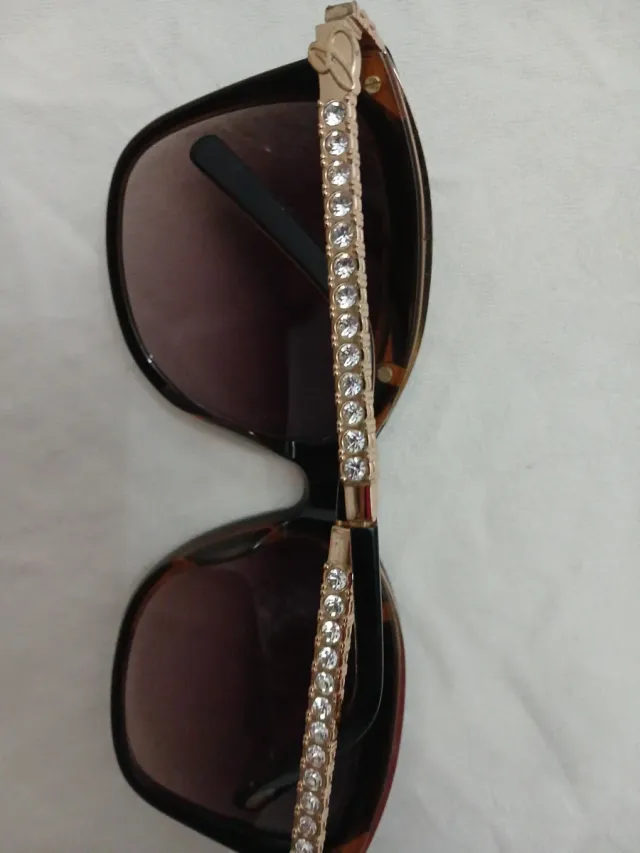 Gafas de sol negras y doradas con pedrería