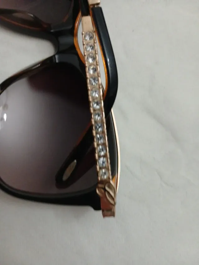 Gafas de sol negras y doradas con pedrería