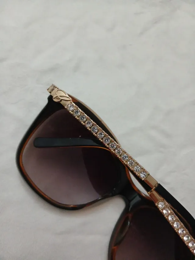 Gafas de sol negras y doradas con pedrería