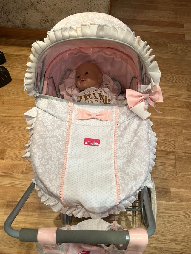 Cochecito de muñecas rosa con muñeco
