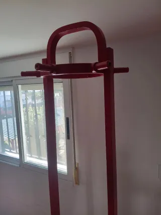 Perchero antiguo de madera pintado de rojo.