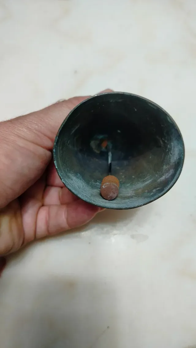 Campana antigua de bronce con símbolo