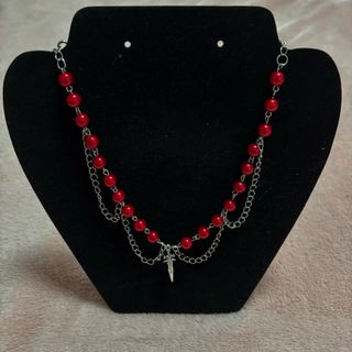 Collar de perlas rojas y cadena con daga