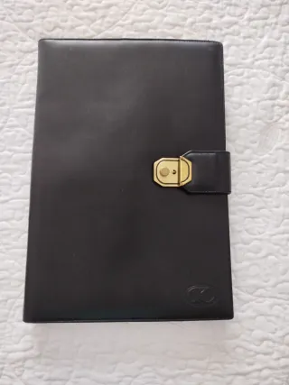 Portafolios de piel negro con cierre dorado.