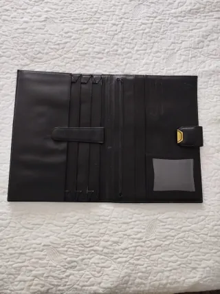 Portafolios de piel negro con cierre dorado.