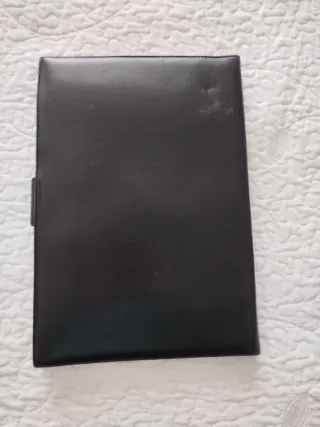 Portafolios de piel negro con cierre dorado.