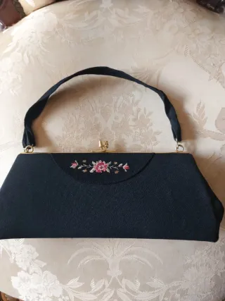 Bolso de mano negro con flores rosas