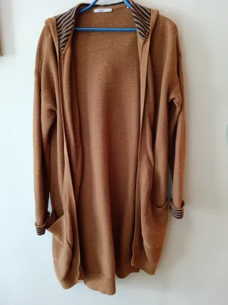 Chaqueta larga con capucha sin botones, es suelta