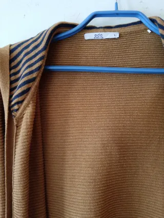 Chaqueta larga con capucha sin botones, es suelta