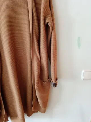 Chaqueta larga con capucha sin botones, es suelta