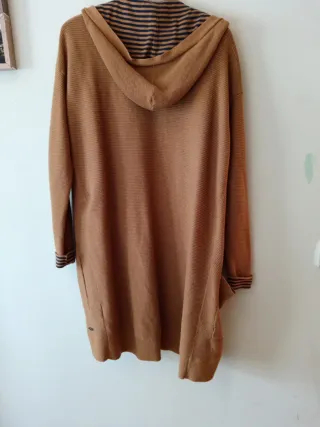 Chaqueta larga con capucha sin botones, es suelta