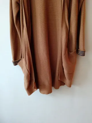 Chaqueta larga con capucha sin botones, es suelta