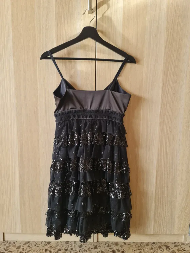 Vestido negro con volantes y lentejuelas.