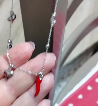 Collana in acciaio con cornetto rosso e cuori