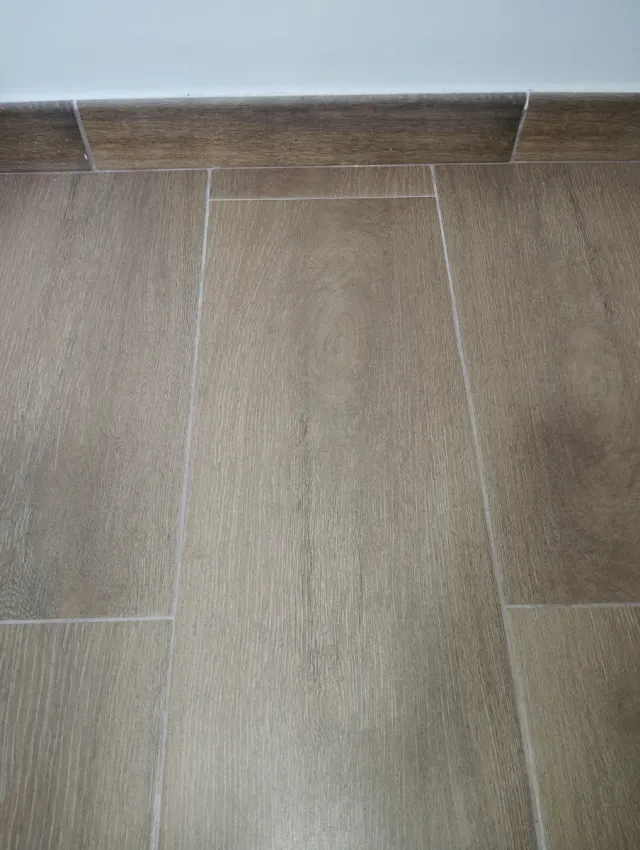 Suelo porcelánico imitación madera y rodapié.