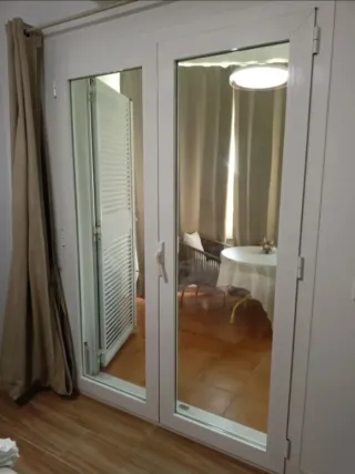 Puerta doble aluminio abatible con veneciana.