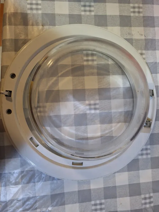 Puerta Lavadora, le falta la bisagra.