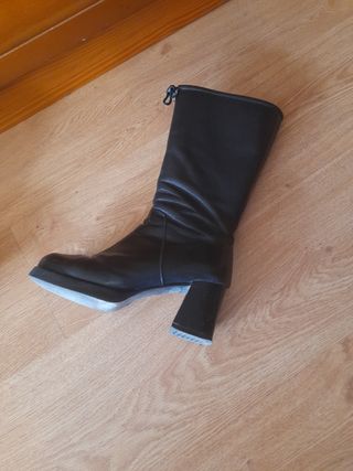 Botas altas de tacón negras. Son de piel.