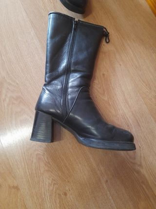 Botas altas de tacón negras. Son de piel.