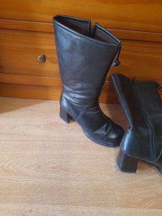 Botas altas de tacón negras. Son de piel.