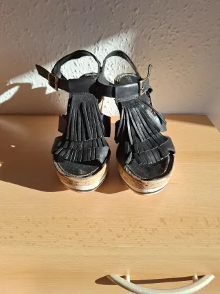 Sandalias negras con cuña y flecos