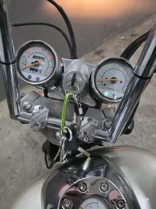 Moto custom plateada con casco