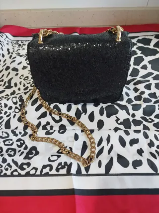 Bolso negro lentejuelas cadena dorada.